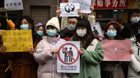 Pendukung Zhou Xiaoxuan, seorang tokoh feminis yang menjadi terkenal selama gerakan #MeToo China, memajang poster di luar Pengadilan Rakyat Distrik Haidian di Beijing pada 2 Desember 2020, dalam kasus pelecehan seksual terhadap salah satu pembawa acara televisi paling terkenal di China. (NOEL CELIS / AFP)