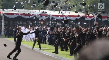 Sejumlah perwira TNI dan Polri melemparkan topi ke udara setelah dilantik Presiden Joko Widodo pada Upacara Prasetya Perwira (Praspa) TNI dan Polri angkatan 2019 di Istana Merdeka, Jakarta, Kamis (16/7/2019). Jokowi melantik 781 perwira TNI dan Polri di Halaman Istana (Liputan6.com/Angga Yuniar)