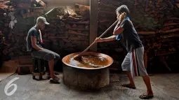 Pekerja mengaduk dodol di industri rumah kawasan Pasar Minggu, Jakarta, Kamis (23/6). Produksi dodol Betawi mengalami peningkatan tajam seiring permintaan jelang Lebaran. (Liputan6.com/Gempur M Surya)