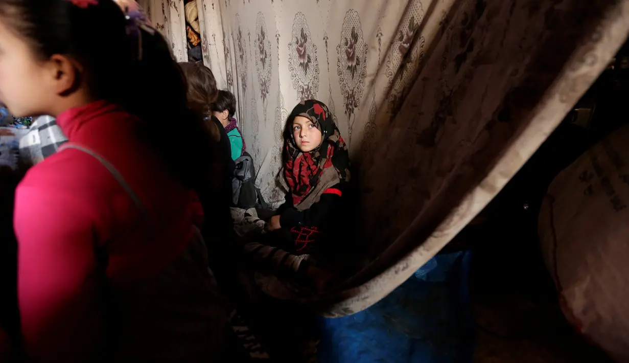 Seorang anak pengungsi saat mengikuti kegiatan belajar di dalam sebuah gua di desa yang dikuasai pemberontak di Tramla, Provinsi Idlib, Suriah, pada 27 Maret 2016. (REUTERS/Khalil Ashawi)