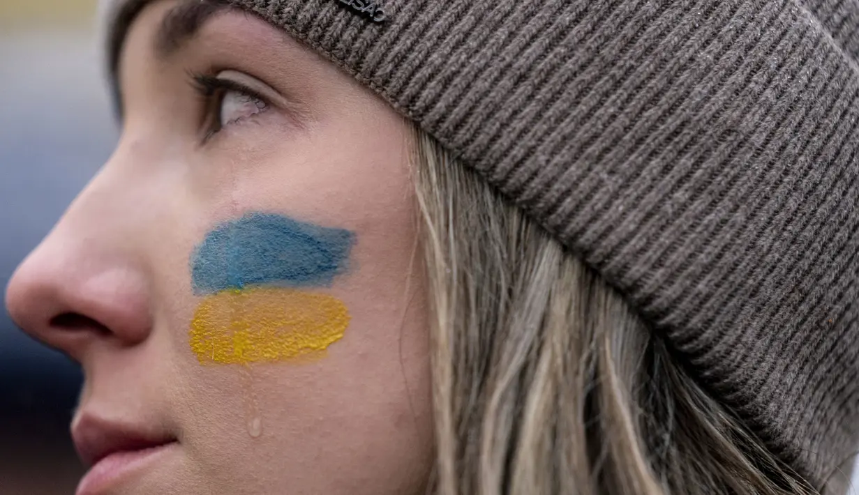 Setetes air mata mengalir di pipi Oleksandra Yashan saat berjaga untuk memprotes invasi Rusia ke Ukraina di Lafayette Park di depan Gedung Putih di Washington, Kamis, 24 Februari 2022. (AP Photo/Andrew Harnik)