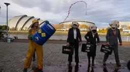 Juru kampanye dari kelompok lingkungan Ocean Rebellion mengenakan topeng kepala ikan saat aksi protes terhadap Marine Stewardship Council (MSC) di Glasgow, Skotlandia, 4 November 2021. Aksi ini dilakukan di sela-sela KTT Iklim PBB COP26 yang sedang berlangsung. (AP Photo/Alastair Grant)