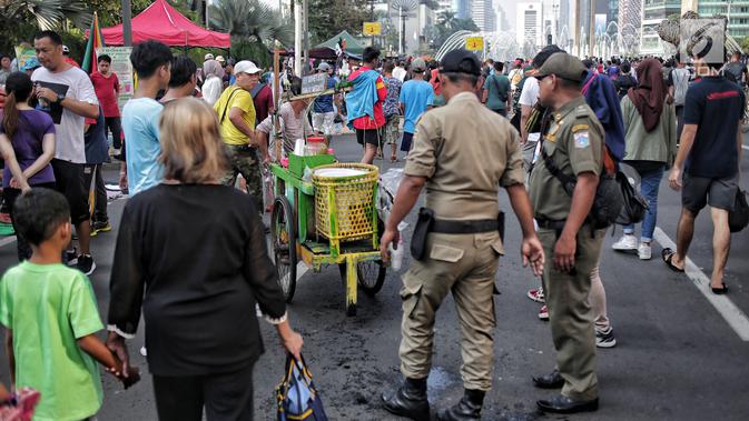 Petugas Satpol PP menertibkan PKL yang berdagang di kawasan Car Free Day, Bundaran HI, Jakarta, Minggu (5/5/2019). Kurangnya pengawasan menyebabkan banyak PKL berjualan tidak pada tempat yang telah di sediakan Pemprov DKI sehingga mengganggu aktivitas warga berolahraga. (Liputan6.com/Faizal Fanani)