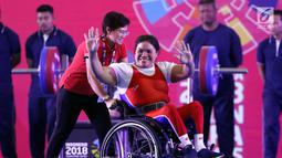 Atlet Para Powerlifting Indonesia, Nurtani Purba melambaikan tangan usai mengangkat beban di kelas Womens Up 73kg Asian Para Games 2018 di Jakarta, Rabu (10/10). Nurtani Purba meraih perak dengan total angkatan 1115 kg. (Liputan6.com/Helmi Fithriansyah)