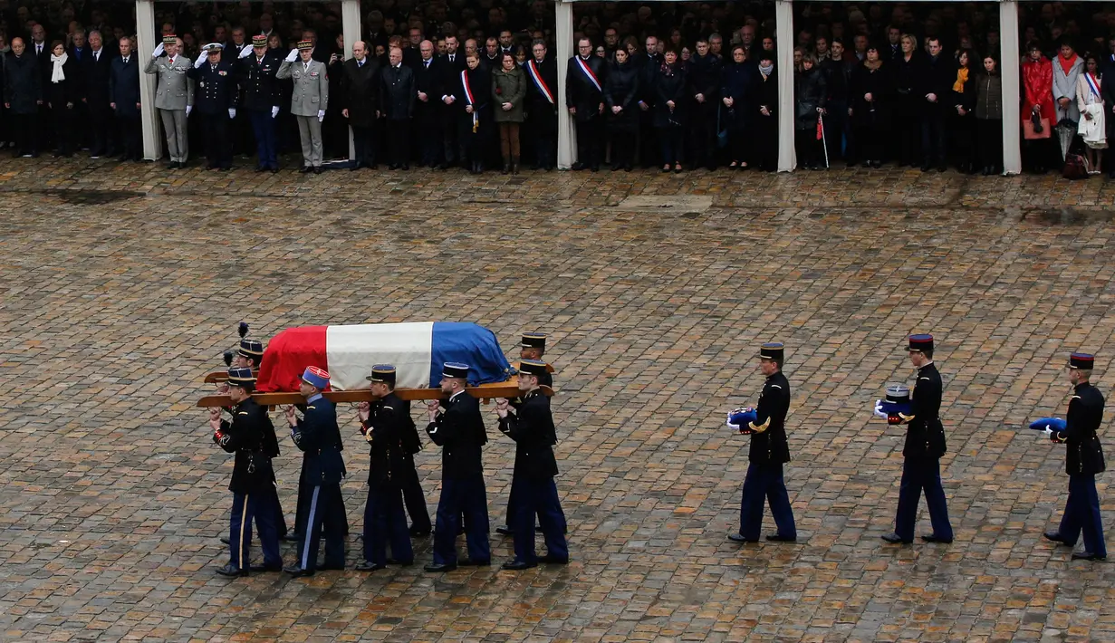 Anggota kepolisian Prancis menggotong peti mati Letnan Kolonel Arnaud Beltrame dalam upacara pemakaman nasional di Hotel des Invalides, Paris, Rabu (28/3). Peti mati Beltrame disambut ratusan orang dalam upacara tersebut. (Ludovic Marin, Pool via AP)
