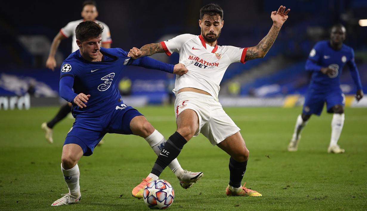 Gelandang Chelsea, Mason Mount, berebut bola atas dengan penyerang Sevilla, Suso, pada laga Grup E Liga Champions 2020/2021 di Stamford Bridge, Rabu (21/10/2020) dini hari WIB. Chelsea bermain imbang 0-0 atas Sevilla. (AFP/Toby Melville/pool)
