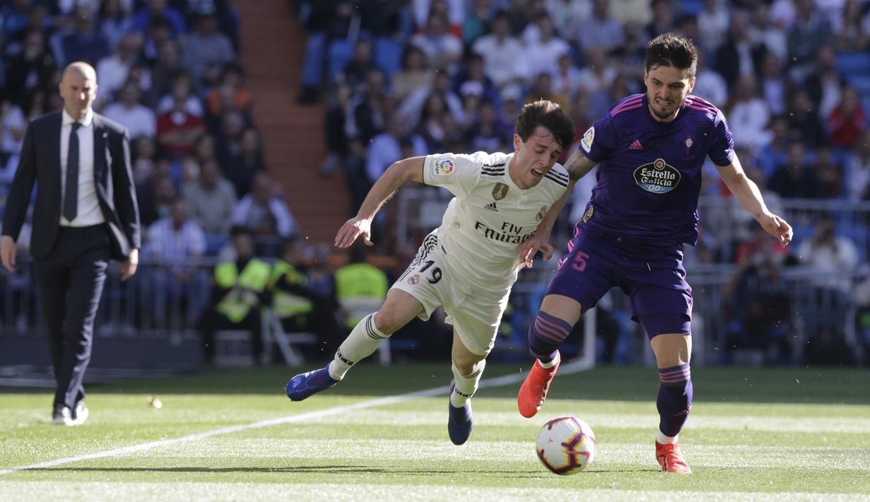 Pemain Real Madrid, Alvaro Odriozola, berusaha melewati pemain Celta Vigo pada laga La Liga 2019 di Stadion Santiago Bernabeu, Sabtu (16/3). Real Madrid menang 2-0 atas Celta Vigo. (AP/Paul White)