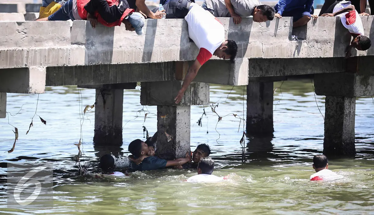 Warga berusaha menolong seorang anak kecil yang terjatuh ke laut di dermaga Muara Angke, Jakarta, Kamis (24/3). Akibat kelalaian ibunya seorang anak tercebur ke laut dan langsung di selamatkan warga dan prajurit TNI AL. (Liputan6.com/Faizal Fanani)