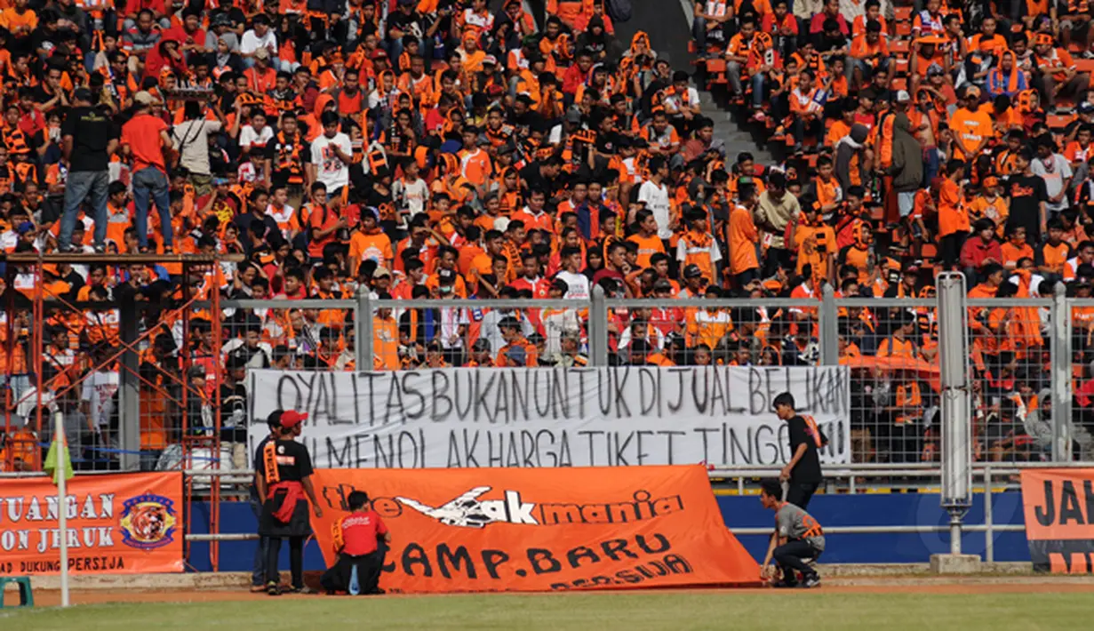 Suporter Persija membentangkan spanduk protes kenaikan harga tiket saat laga Persija melawan Persela di Stadion GBK Jakarta, Minggu (1/3/2015). (Liputan6.com/Helmi Fithriansyah)
