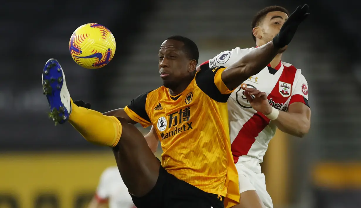 Bek Wolverhampton Wanderers, Willy Boly, berebut bola dengan gelandang Southampton, Che Adams, pada laga lanjutan Liga Inggris di Molineux Stadium, Selasa (24/11/2020) dini hari WIB. Wolverhampton imbang 1-1 menghadapi Southampton. (AFP/Andrew Boyers/pool)