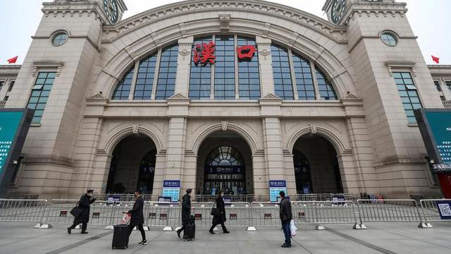 Orang-orang berjalan melewati Stasiun Kereta Api Hankou yang ditutup di Wuhan, Provinsi Hubei, China, Kamis (23/1/2020). Pemerintah China mengisolasi Kota Wuhan yang berpenduduk sekitar 11 juta jiwa untuk menahan penyebaran virus corona.