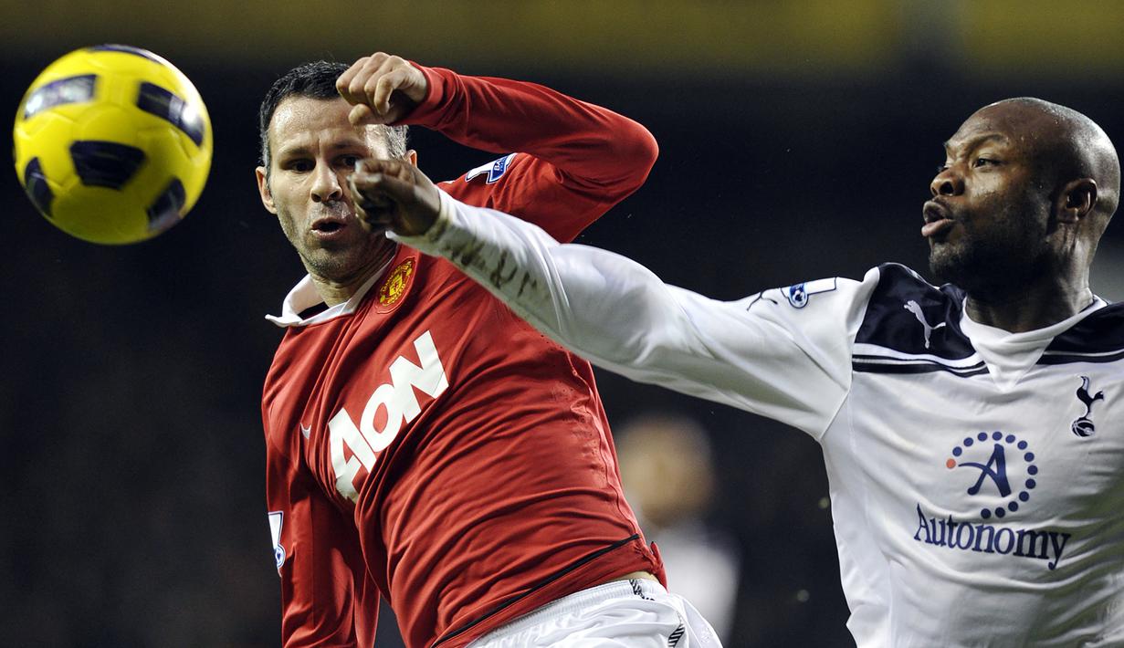Gelandang Manchester United, Ryan Giggs (kiri) berebut bola dengan bek Tottenham Hotspur, William Gallas pada laga Liga Inggris 2010/2011 di White Hart Line Stadium, London (16/1/2011). Ryan Giggs total mencetak 109 gol dari 620 laga bagi MU di Premier League sejak edisi pertama pada 1992/1993 hingga 2012/2013 saat Sir Alex Ferguson memutuskan pensiun. Pada 2013/2014 ia sempat berstatus pemain merangkap manajer MU di bawah kepemimpinan David Moyes. (AFP/Glyn Kirk)