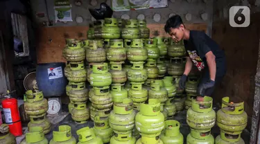 Pekerja menata tabung liquefied petroleum gas (LPG) 3 Kg di sebuah agen di kawasan Jakarta, Rabu (27/12/2023). Pemerintah mendorong penyaluran LPG 3 Kg lebih tepat sasaran dengan menggunakan Kartu Tanda Penduduk (KTP) mulai 1 Januari 2024. (Liputan6.com/Angga Yuniar)