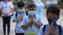 Siswa yang memakai masker berdoa pada hari pertama kelas tatap muka di sekolah dasar Comembo di kota Makati, Filipina, Senin (6/12/2021). Beberapa sekolah di Manila diizinkan dibuka kembali setelah berbulan-bulan lamanya karena kasus COVID-19 terus menurun di negara tersebut. (AP Photo/Aaron Favila)
