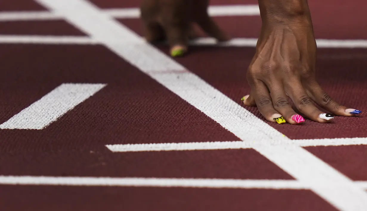 Javianne Oliver, dari Amerika Serikat, bersiap untuk memulai pertandingan lari 100 meter putri pada Olimpiade Musim Panas 2020 di Tokyo, Jepang, Jumat (30/7/2021). Sprinter AS memberi hiasan pada kukunya saat bertanding.  (AP Photo/Matthias Schrader)