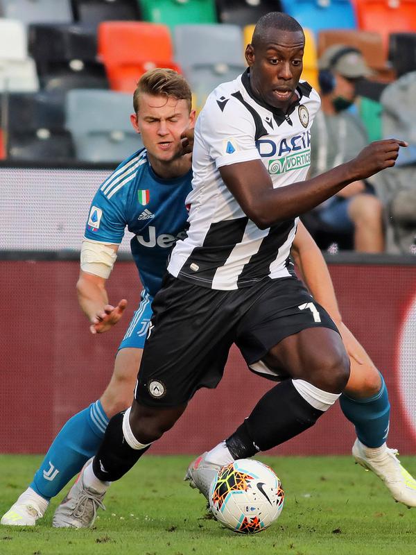 Penyerang Udinese, Stefano Okaka membawa bola dari kawalan bek Juventus, Matthijs de Ligt pada pertandingan Liga Serie A Italia di Stadion Dacia Arena di Udine (23/7/2020). Juventus masih bertengger di puncak klasemen Liga Italia dengan 80 poin. (Andrea Bessanutti/LaPresse via AP)