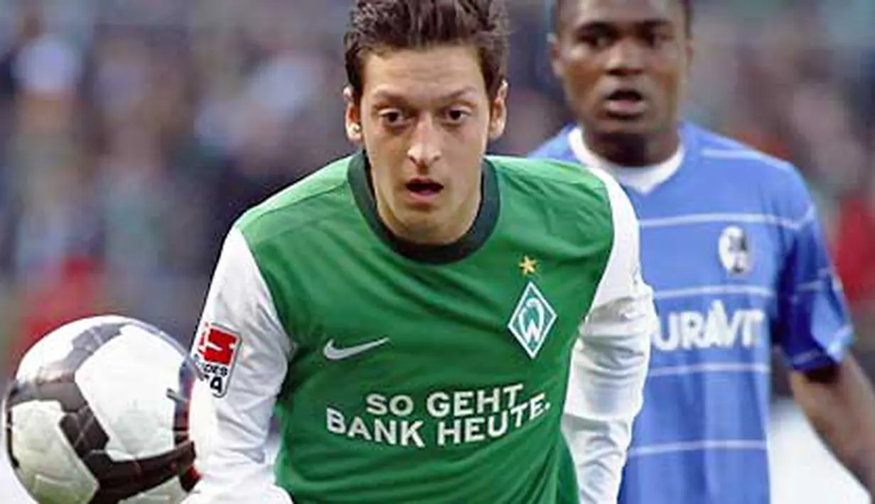 Aksi gelandang Werder Bremen Mesut Oezil (depan) dibayangi striker Freiburg Cedric Makiadi di laga lanjutan Bundesliga yang berlangsung di Bremen, 10 April 2010. Werder unggul 4-0. AFP PHOTO DDP / PHILIPP GUELLAND