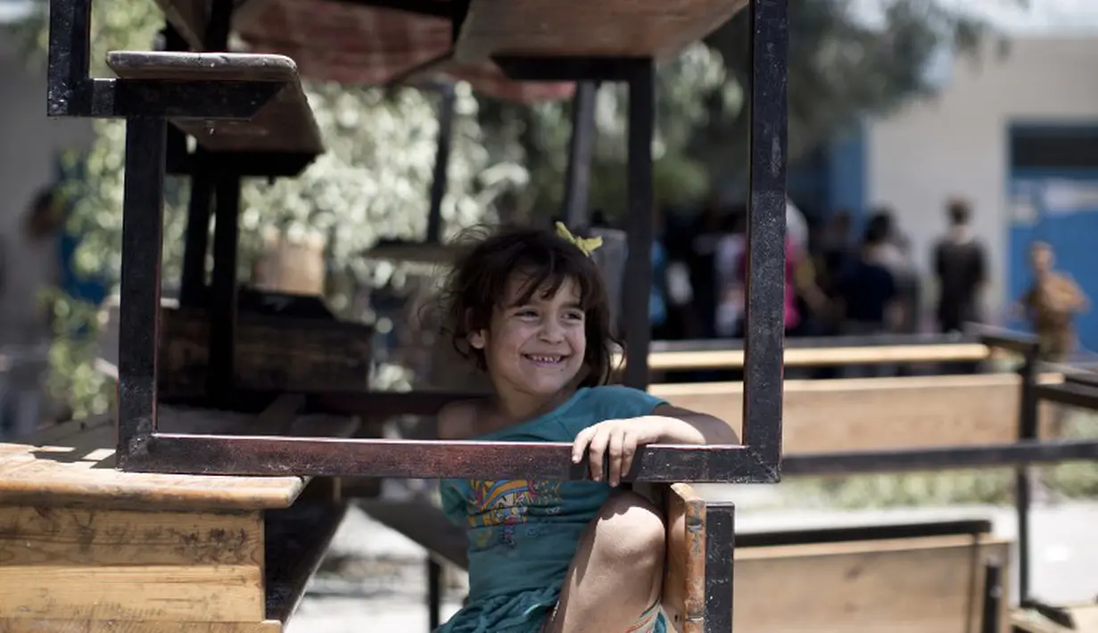 Seorang anak Palestina bermain di kamp pengungsi Sekolah PBB di Jabalia, Gaza (30/7/14). (AFP PHOTO/Mahmud HAMS)