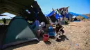 Warga mencuci peralatan masak di samping tenda di sebuah lapangan terbuka di Marapokot, Nagekeo, Nusa Tenggara Timur, Senin, 17 Agustus 2026, (AFP/ Juni Kriswanto)