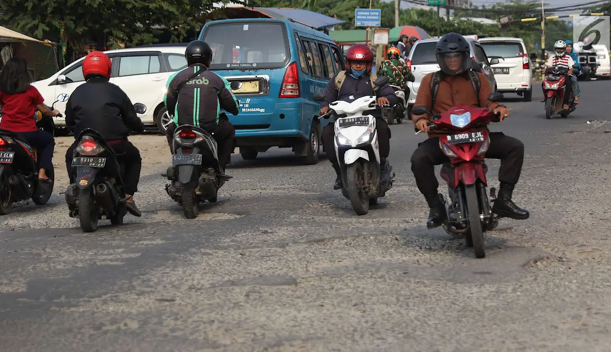 Lalu lalang kendaraan saat jalan berlubang di kawasan Gas Alam, Depok, Jawa Barat, Kamis (4/10). Hingga kini kondisi jalan rusak di kawasan tersebut tidak diperbaiki oleh pihak terkait. (Liputan6.com/Immanuel Antonius)