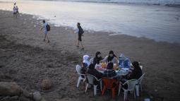 Sekelompok perempuan bersiap untuk berbuka puasa Ramadhan di tepi pantai di Rabat, Maroko, Sabtu (23/4/2022). Untuk pertama kalinya dalam dua tahun sejak pandemi COVID-19, orang-orang dapat menghidupkan kembali tradisi Ramadhan dengan berkumpul dan berbuka puasa di tempat umum. (AP Photo/Mosa'ab Elshamy)