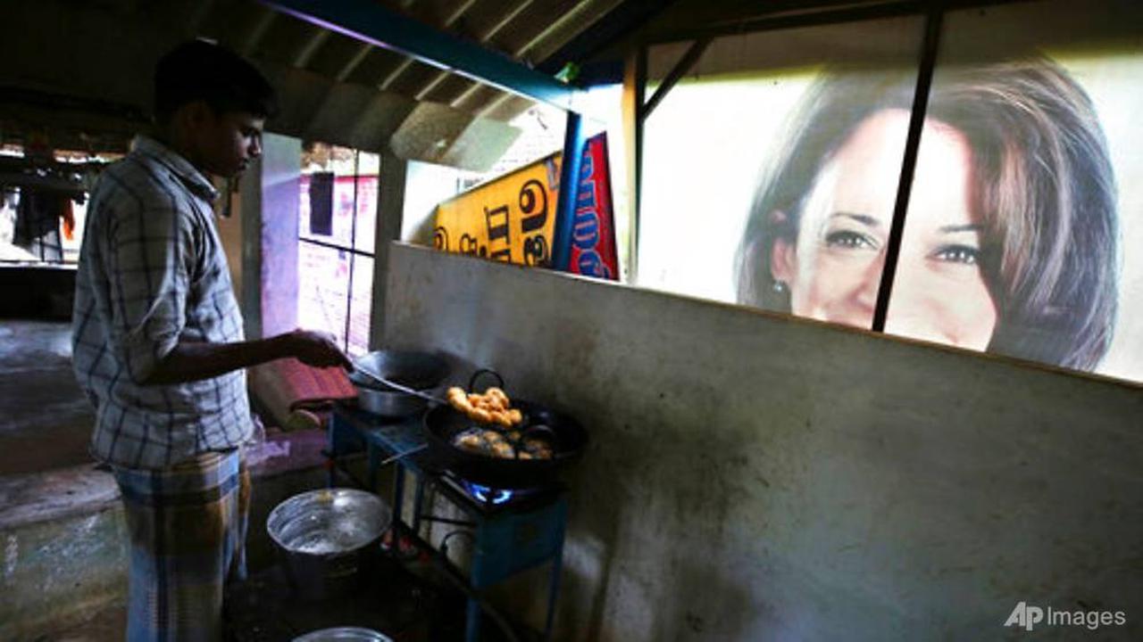 Seorang pekerja menyiapkan camilan tradisional di sebelah spanduk yang menampilkan Kamala Harris di luar restoran lokal di Thulasendrapuram, selatan Chennai, Tamil Nadu, India, 20 Jan 2021.