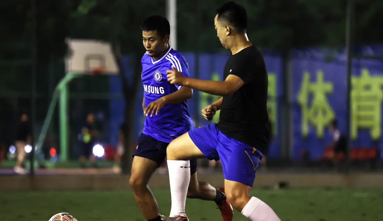 Orang-orang bermain sepak bola pada malam hari di lapangan sepak bola Guangming Square, Yinchuan, Daerah Otonom Etnis Hui Ningxia, China, 5 Agustus 2020. Kota Yinchuan menyediakan berbagai fasilitas (venue) olahraga yang memadai bagi warganya untuk berolahraga di malam hari. (Xinhua/Jia Haocheng)
