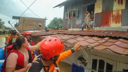 Tim penyelamat mengevakuasi warga di tengah banjir akibat hujan deras semalam di Medan, Sumatera Utara (4/12/2020). Seorang warga Kampung Lalang, Medan, Dean Ramadhan mengatakan, banjir yang terjadi kali ini tergolong parah. (AFP/Rahmad Suryadi)