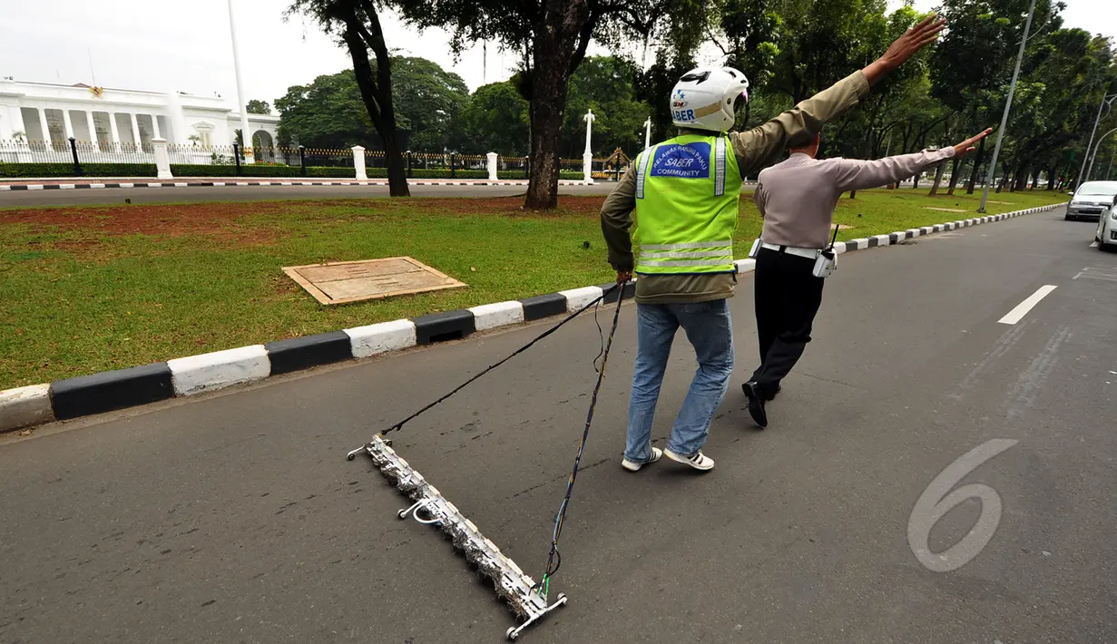 Relawan Saber saat membersihkan paku di jalan di depan Istana Merdeka, Jakarta, Jumat (6/3/2015). Paku yang ditebar oleh orang tidak bertangung jawab seringkali mengganggu para pengguna jalan. (Liputan6.com/Faizal Fanani)