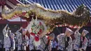 Penduduk memainkan "Kinryu no Mai," atau Tarian Naga Emas di Kuil Sensoji di Tokyo, (18/10/2021). Kebanyakan naga Jepang adalah dewa air yang terkait dengan curah hujan dan badan air, dan biasanya digambarkan sebagai makhluk besar, tak bersayap, ular dengan kaki cakar. (AP Photo/Eugene Hoshiko)