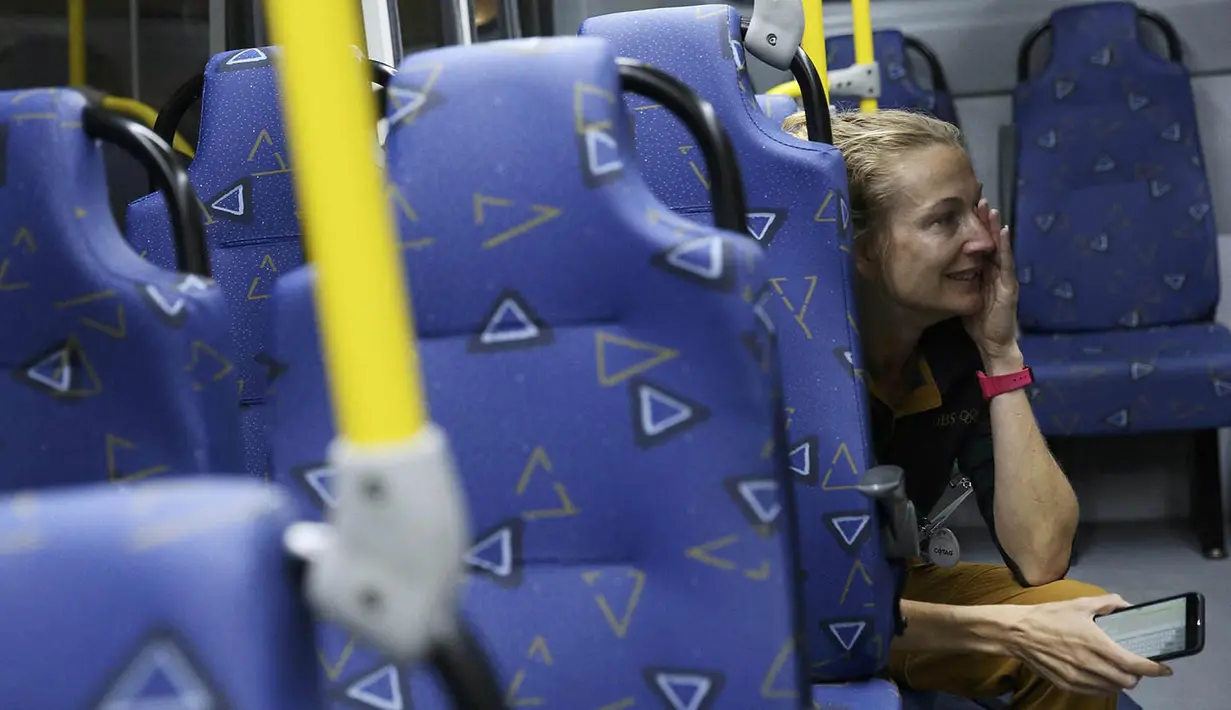 Seorang wartawan menangis ketakutan saat sebuah bus yang mengangkut sejumlah jurnalis di Olimpiade Rio 2016 terkena peluru nyasar pada Selasa (9/8/2016) malam waktu Brasil. (Reuters/Shannon Stapleton)