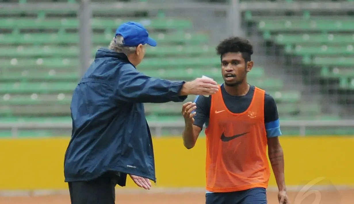 Pelatih timnas Indonesia, Alfred Riedl (kiri) berbincang dengan Imanuel Wanggai di sela-sela latihan di Stadion GBK Jakarta, Kamis (13/11/2014). (Liputan6.com/Helmi Fithriansyah)