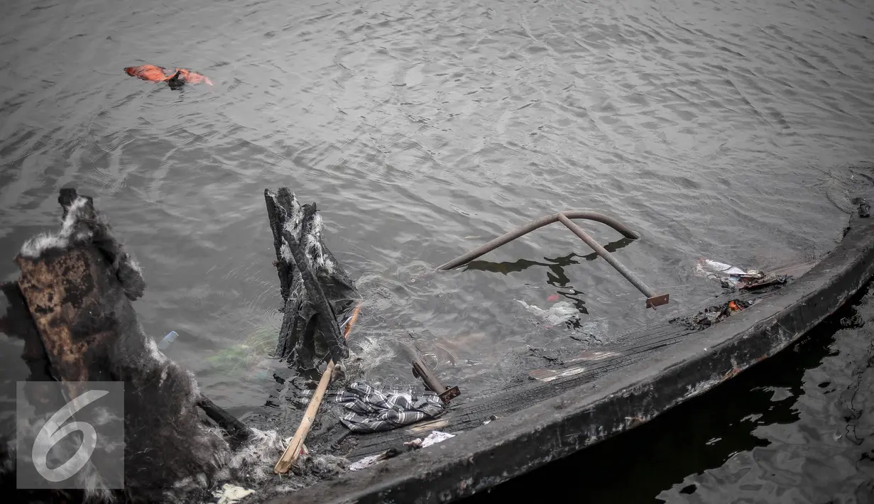 Bangkai kapal Zahro yang terlihat hangus mulai tenggelam di pelabuhan Muara Angke, Jakarta, Selasa (3/1). Kapal yang terbuat dari material kayu dilapisi serat fiber ini hanya terlihat sisa puing. (Liputan6.com/Faizal Fanani)