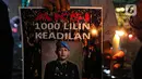 Massa aksi yang tergabung dalam Tim Advokat Penegak Hukum dan Keadilan (Tampak) menunjukkan poster bergambar Brigadir Yosua Hutabarat atau Brigadir J saat aksi 1000 lilin atas kematiannya di Bundaran HI, Jakarta, Jumat (22/7/2022). Aksi tersebut sebagai bentuk keadilan terkait kematian Brigadir J yang diduga akibat penyiksaan. (Liputan6.com/Faizal Fanani)