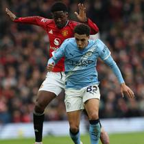 Gelandang Manchester United asal Inggris bernomor punggung 37, Kobbie Mainoo, berduel dengan bek Manchester City asal Inggris bernomor punggung 82, Rico Lewis, selama pertandingan Liga Inggris antara Manchester United dan Manchester City di Old Trafford, Manchester, barat laut Inggris, pada 17 Januari 2026. (Darren Staples/AFP)