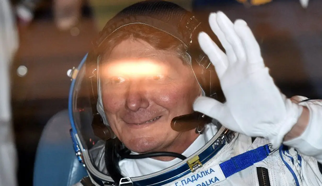 Kosmonot Rusia Gennady Padalka melambaikan tangan saat berada dalam bus pada 27 Maret 2015 lalu. Bersama astronot AS, Scott Kelly, Gennady Padalka dijadwalkan lepas landas menuju ISS dari Baikonur, 28 Maret 2015. (AFP PHOTO/Kirill KUDRYAVTSEV)