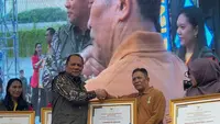 Pelaksana Harian Bina Pemerintahan Desa (Pemdes) Kemendagri La Ode Ahmad P Bolombo (kiri) sedang menyerahkan penghargaan kepada Provinsi dan Kabupaten/Kota yang berhasil membina desa dan kelurahan di ajang Pindeskel 2023, di Lapangan Banteng, Jakarta, Jumat (10/11/2023). (Ist)