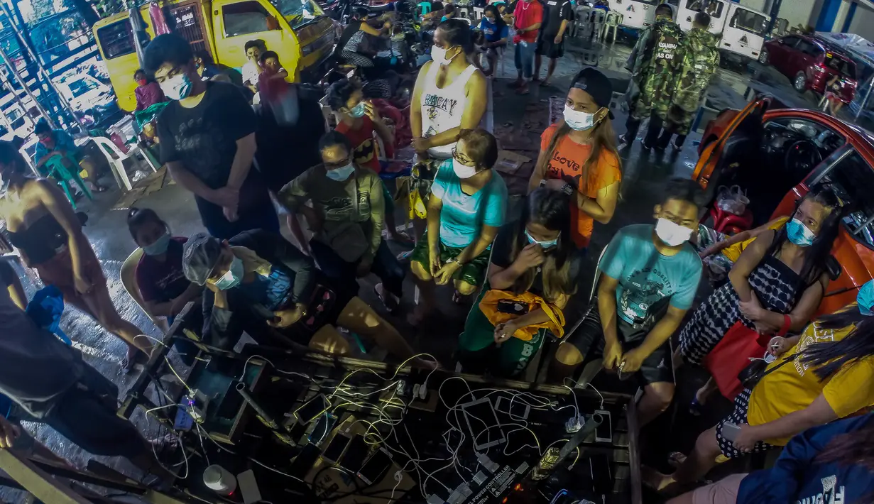 Warga mengisi daya ponsel saat berlindung di pusat evakuasi Quezon City, Filipina, 12 November 2020. Topan Vamco, topan dahsyat ketiga yang melanda Filipina dalam 11 hari terakhir, membawa angin kencang dan hujan deras yang memicu tanah longsor, longsor batu, serta bandang. (Xinhua/Rouelle Umali)