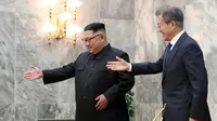 Pemimpin Korut Kim Jong-un mempersilahkan Presiden Korsel Moon Jae-in saat menyambutnya di Panmunjom, Korea Utara (26/5). Mereka bertemu di zona demiliterisasi yang memisahkan kedua negara. (South Korea Presidential Blue House/Yonhap via AP)