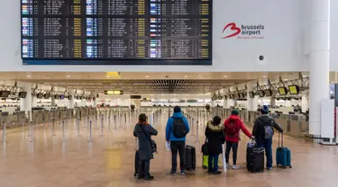 Penumpang melihat layar informasi keberangkatan di Bandara Brussels, Zaventem, Belgia, Rabu (13/2). Menurut badan lalu lintas udara Skeyes, wilayah udara Belgia ditutup selama 24 jam. (AP Photo/Geert Vanden Wijngaert)