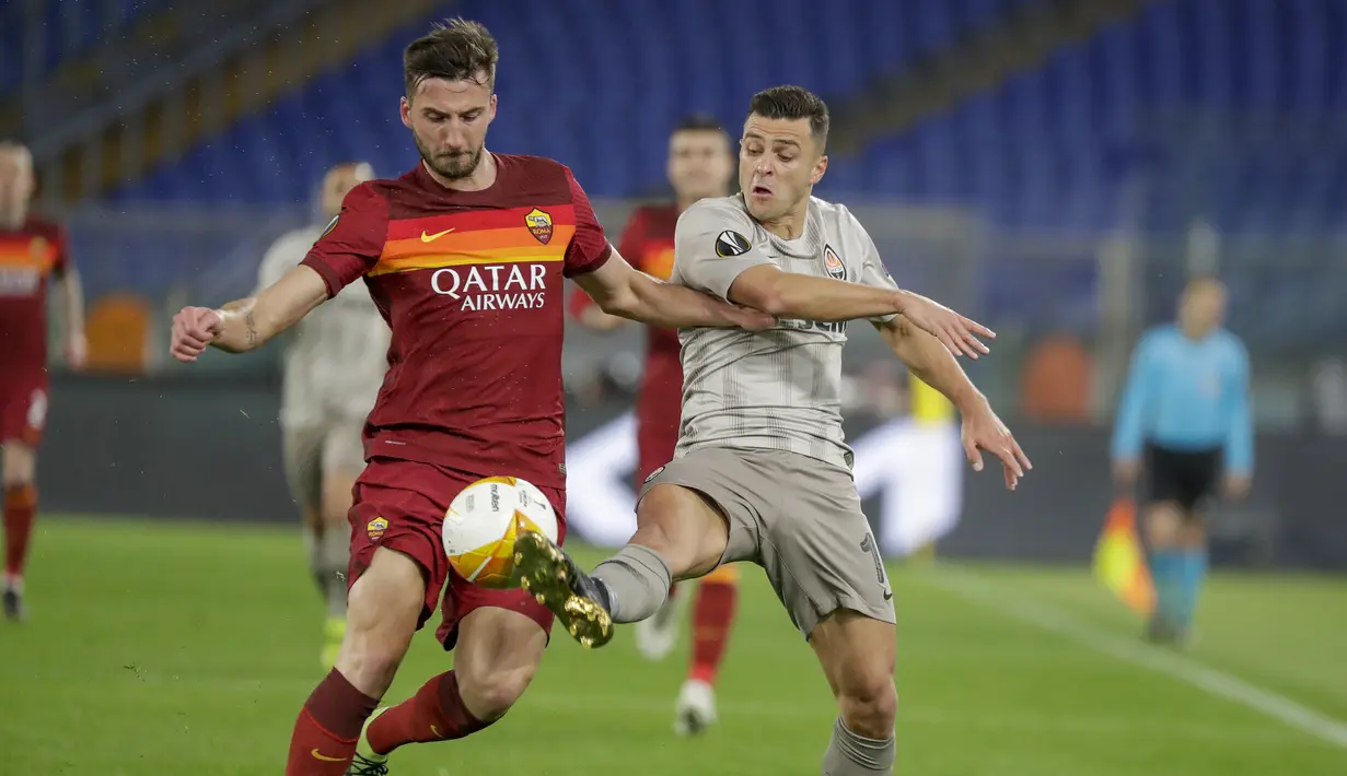 Gelandang AS Roma, Bryan Christante (kiri) berebut bola dengan striker Shakhtar Donetsk, Junior Moraes dalam laga leg pertama babak 16 besar Liga Europa 2020/2021 di Olimpico Stadium, Kamis (11/3/2021). AS Roma menang 3-0 atas Shakhtar Donetsk. (AP/Andrew Medichini)