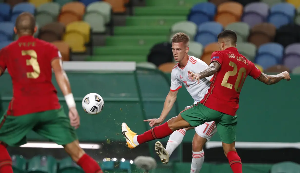 Gelandang Spanyol, Dani Olmo mengumpan bola dari kawalan pemain Portugal, Joao Cancelo pada pertandingan persahabatan di stadion Jose Alvalade di Lisbon, Rabu (7/10/2020). Spanyol bermain imbang 0-0 atas Portugal. (AP Photo/Armando Franca)