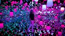 Seorang wanita menikmati ruangan yang penuh instalasi lampu gantung di Mori Building Digital Museum Seni, Tokyo, Jepang (1/5). (AFP Photo/Behrouz Mehri)