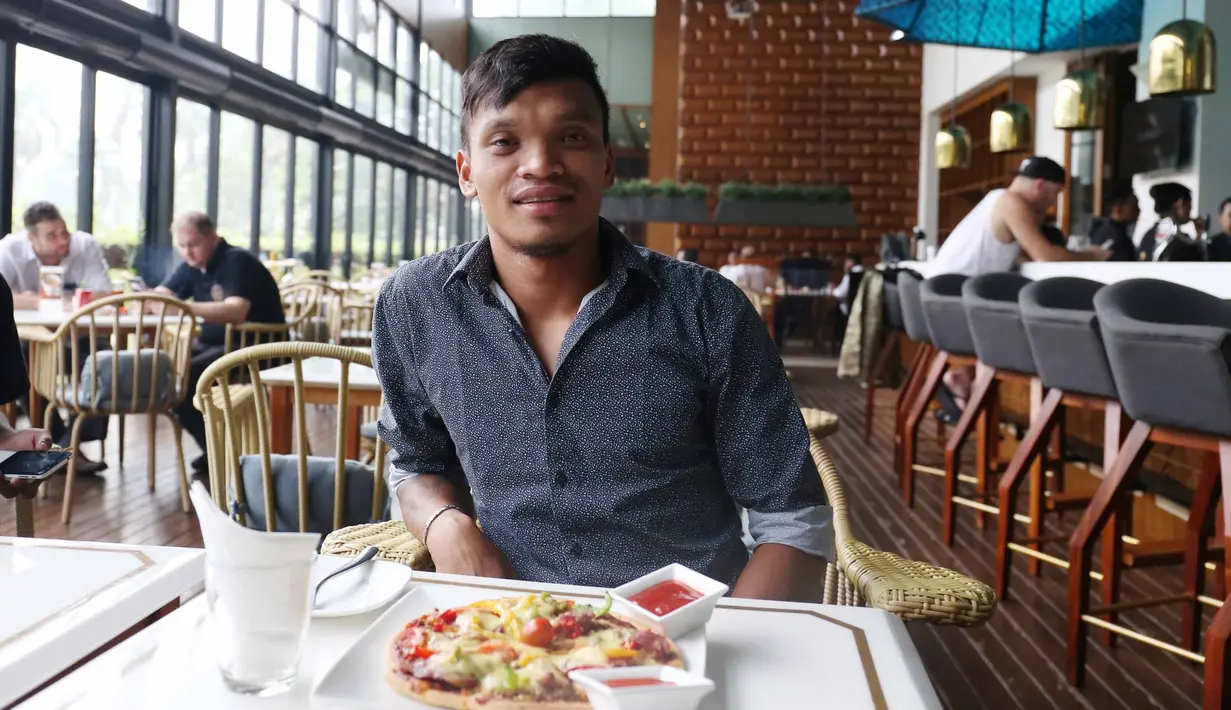Pemain Sriwijaya FC, Ferdinand Sinaga menikmati Piza usai menjalani sidang Komisi Disiplin di Hotel Century, Senayan. Jakarta, Jumat (4/12/2015). (Bola.com/Nicklas Hanoatubun)
