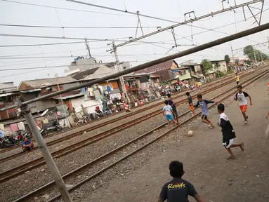 Suasana di pinggir rel kereta api di kawasan Kemayoran, Jakarta, Senin (24/7). Minimnya lahan bermain menyebabkan anak-anak terpaksa bermain di lokasi tersebut, meskipun berbahaya bagi keselamatan. (Liputan6.com/Immanuel Antonius)