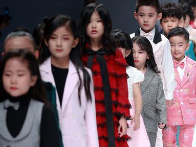 Model anak-anak membawakan busana rancangan KUNJIE oleh Liu Shuming  pada gelaran China Fashion Week di Beijing, China, Selasa (27/10/2020). (STR / AFP)