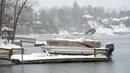 Perahu dan dermaga tertutup salju saat badai musim dingin di Danau James, Morganton, North Carolina, Amerika Serikat, 16 Januari 2022. Jarak pandang terbatas karena es, salju, dan angin menyapu area tersebut. (AP Photo/Kathy Kmonicek)