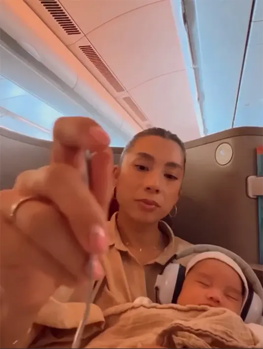 Kiro Zayden Bachdim anak keempat berjenis kelamin laki-laki itu tampak tertidur pulas dalam gendongan Jennifer. Saat putranya tidur, Jennifer memanfaatkan untuk makan cemilan di dalam pesawat. [Instagram/jenniferbachdim]