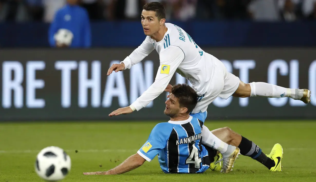 Striker Real Madrid, Cristiano Ronaldo, terjatuh saat berebut bola dengan pemain Gremio, Walter Kannemann, pada final Piala Dunia Antarklub di Stadion Syeikh Zayed, Abu Dhabi, Sabtu (16/12/2017). Real Madrid menang 1-0 atas Gremio. (AP/Hassan Ammar)