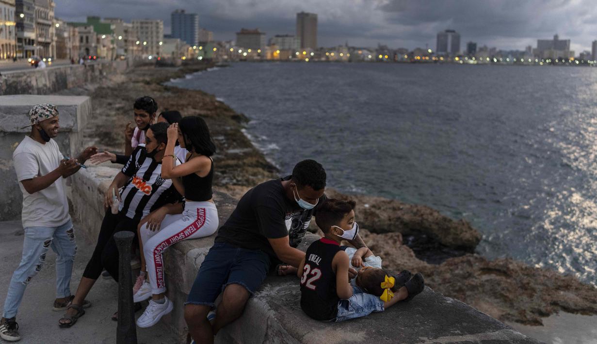 Orang-orang menghabiskan sore hari di Malecon di Havana, Kuba, pada Rabu (29/9/2021). Pihak berwenang di Kuba mulai melonggarkan pembatasan COVID-19 di beberapa kota seperti Havana dan Varadero. (AP Photo/Ramon Espinosa)